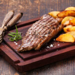 Well Done Grilled New York Steak With Roasted Potato Wedges On C