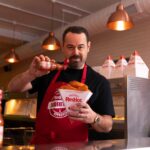 See Danny in a chippy apron greeting fans with free portions of Frank’s fish and chips