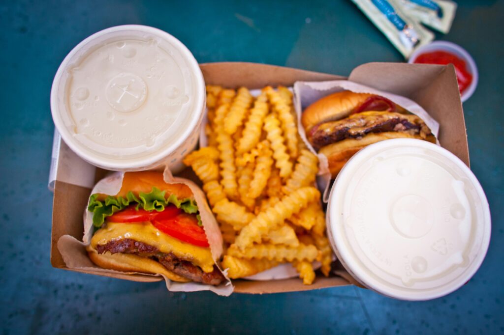 Delicious cheeseburger meal with crinkle-cut fries and drinks, perfect for a quick lunch or fast food craving.