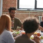 A diverse group of friends sharing a meal and drinks in a cozy restaurant setting.