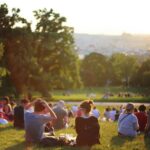 People relaxing and enjoying a sunny day in a bustling city park.