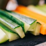 Fresh cucumber and carrot sticks arranged on a slate plate, ready for snacking.